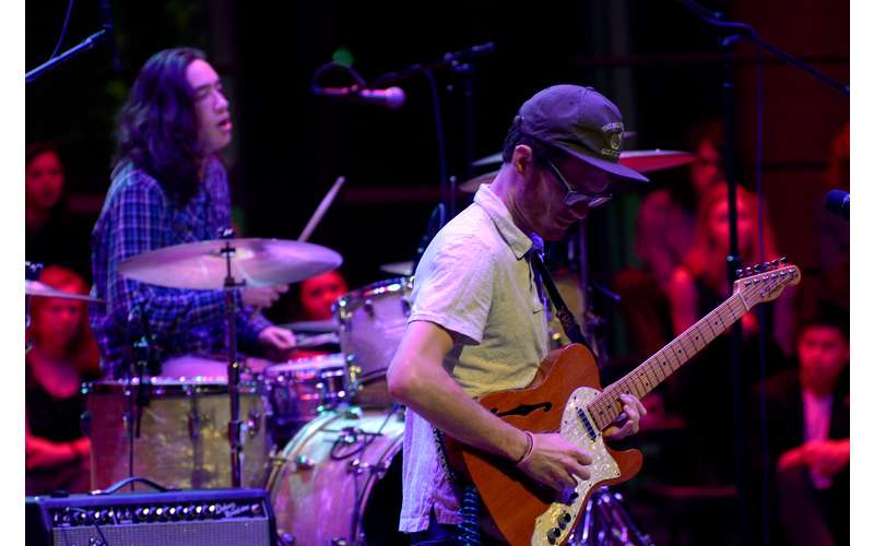 musicians on stage playing guitar and drums