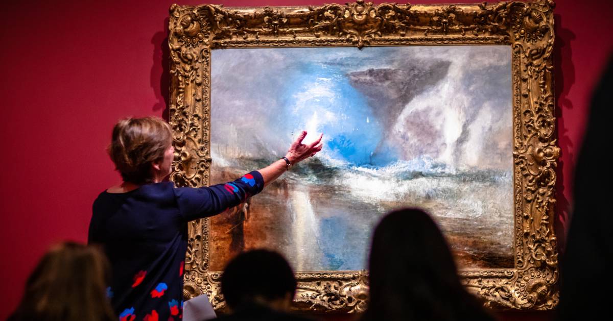 woman showing painting in museum