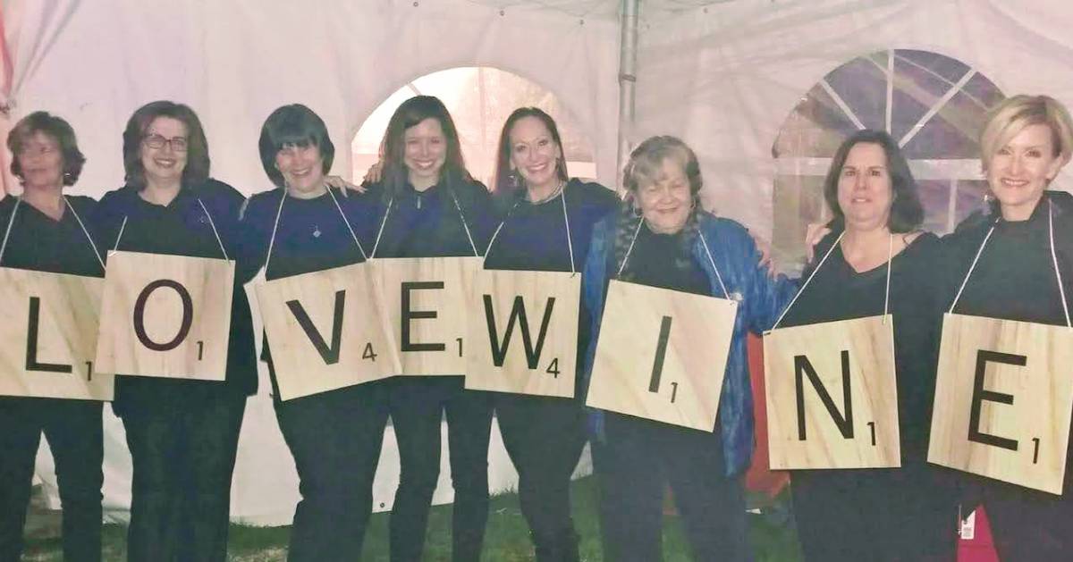 women in scrabble letter costumes spelling out love wine