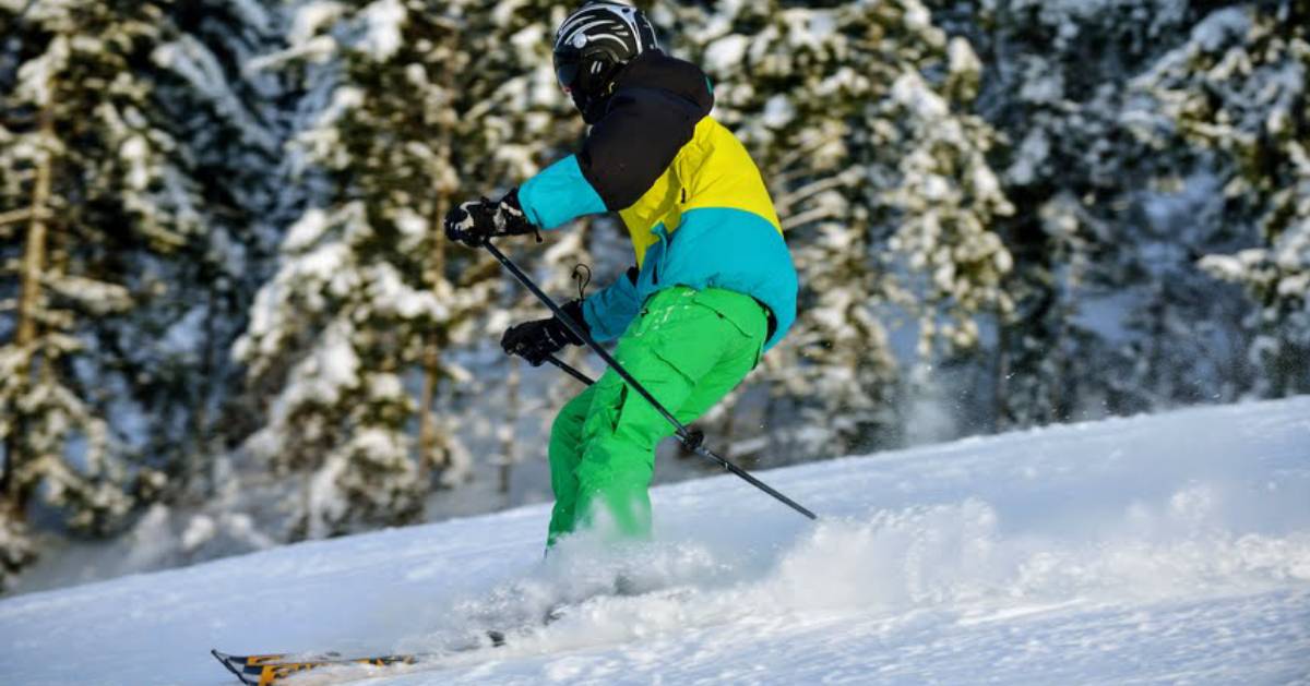 skier on mountain in bright clothes