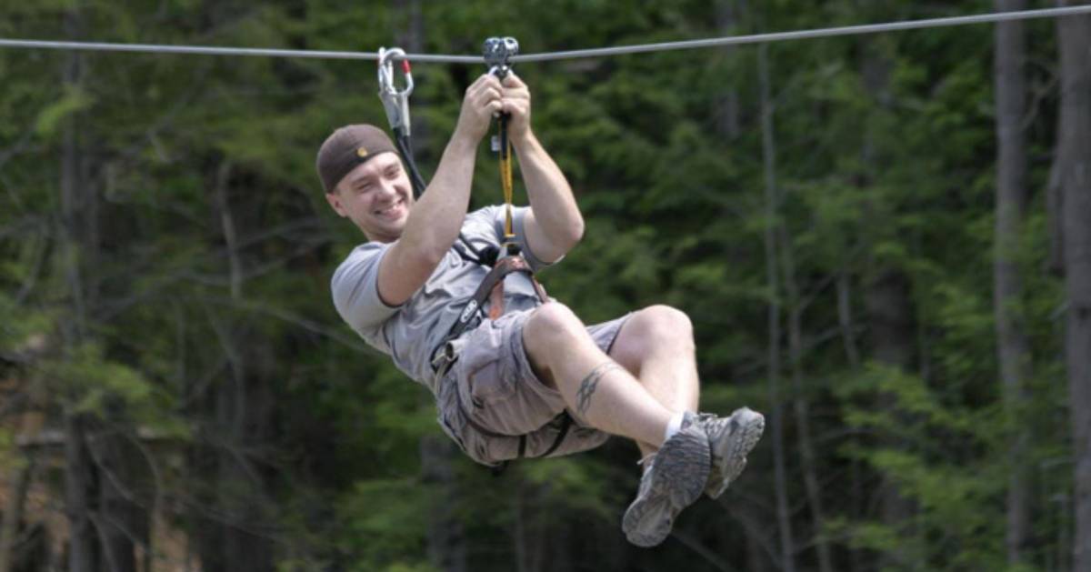 man grinning while on zip line