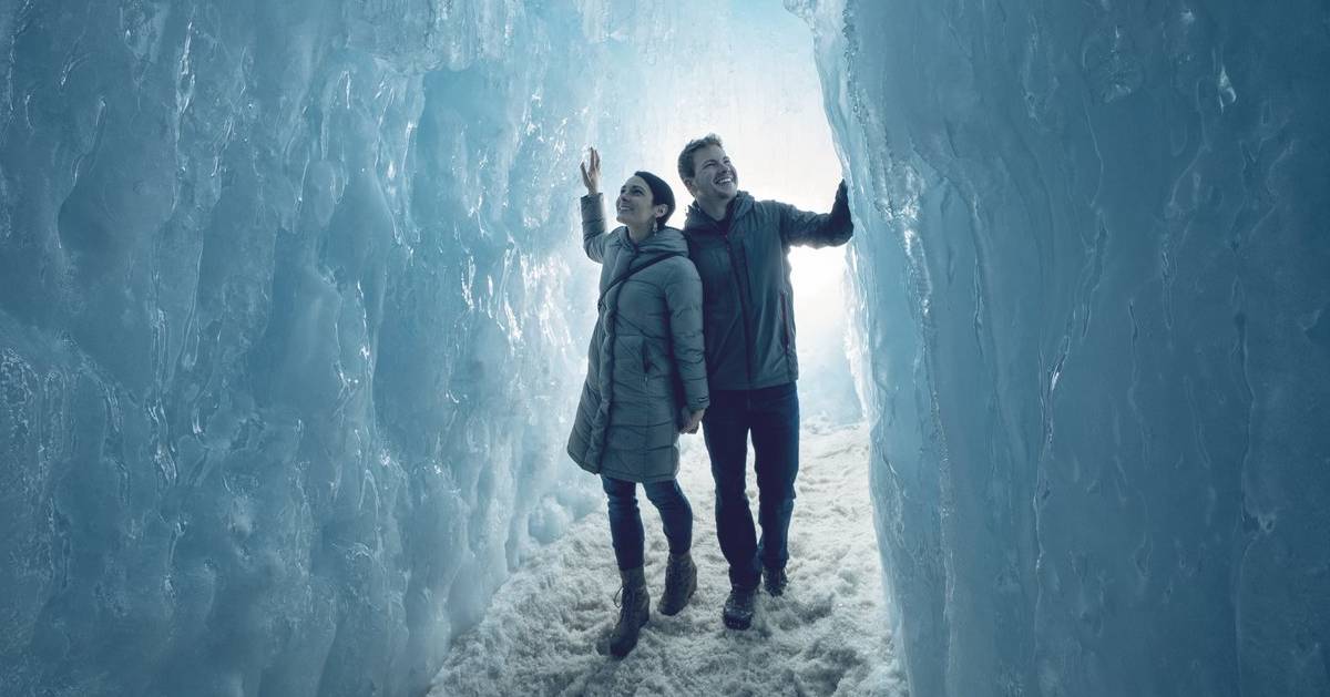 couple walks through ice castle