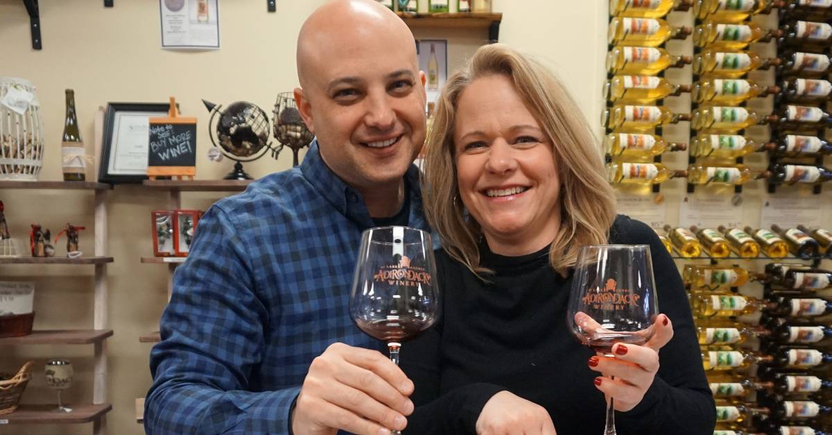 man and woman with wine glasses in a winery tasting room