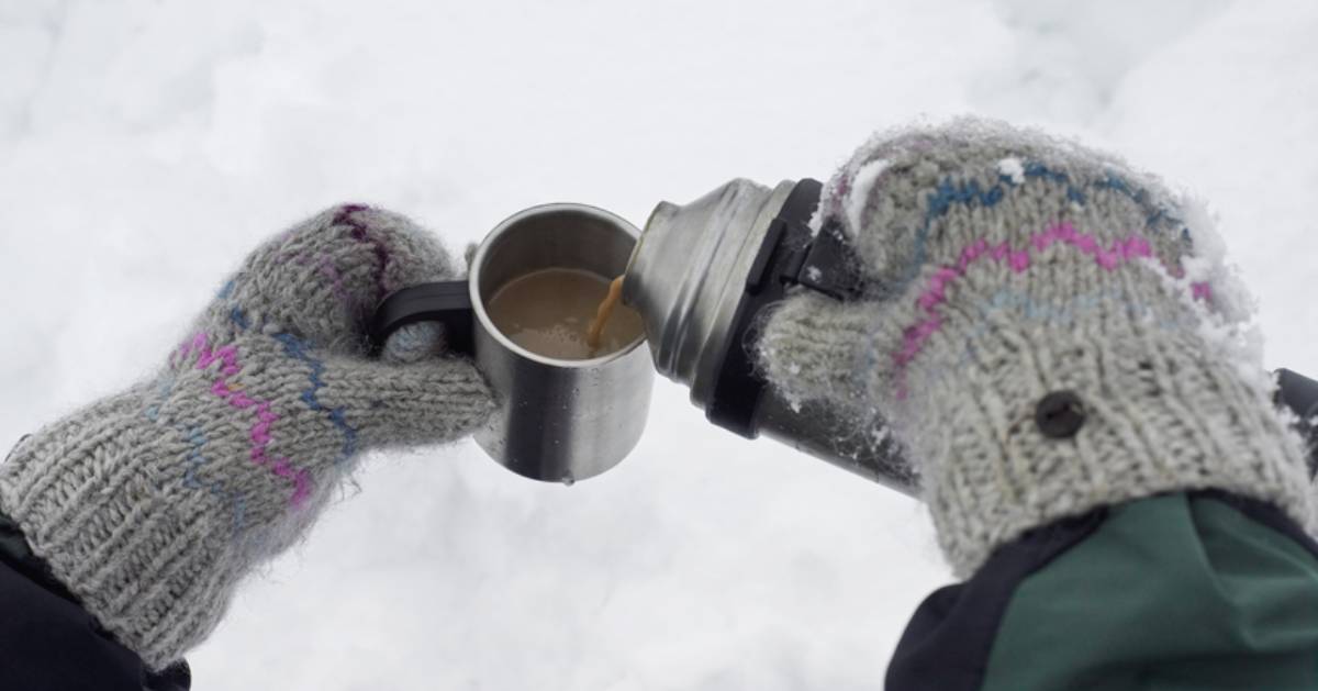 hands with gloves pouring hot chocolate