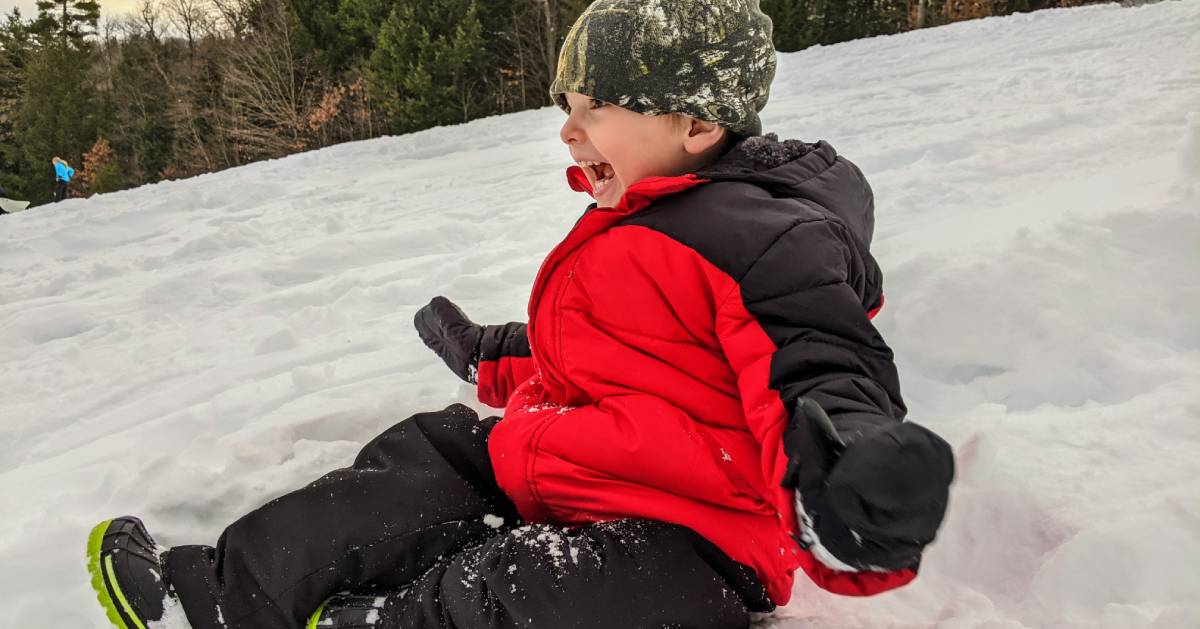 kid smiling and laughing on hill