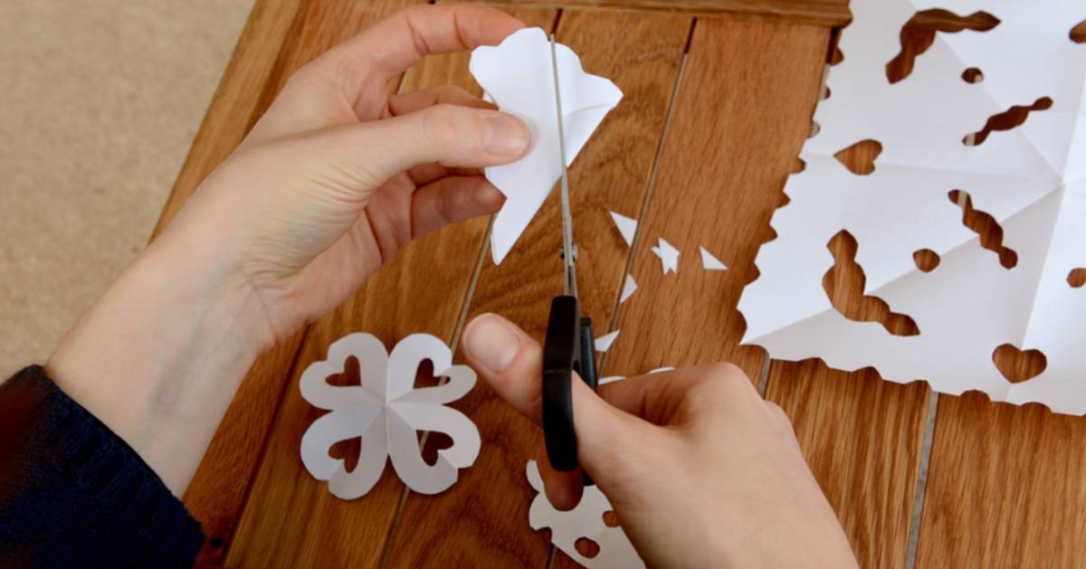 hands making paper snowflakes