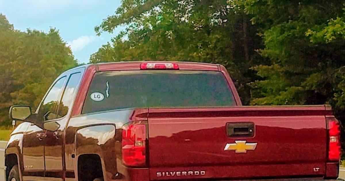 back of a red truck with the sticker of Lake George on the window