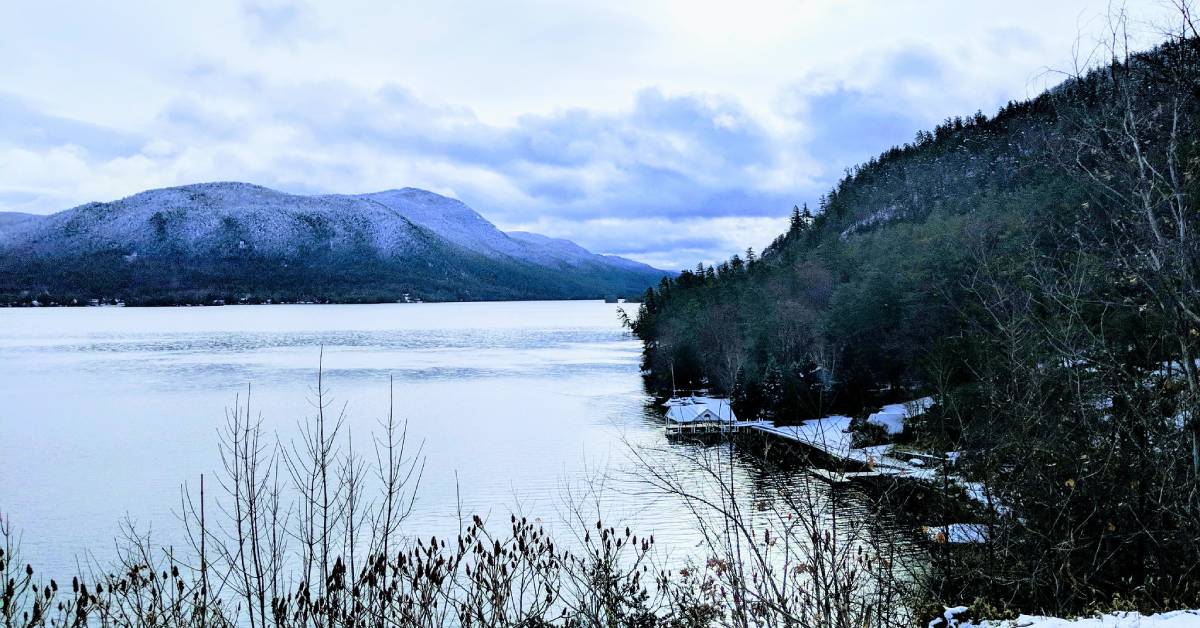 view of a lake and a snow covered mountain in winter
