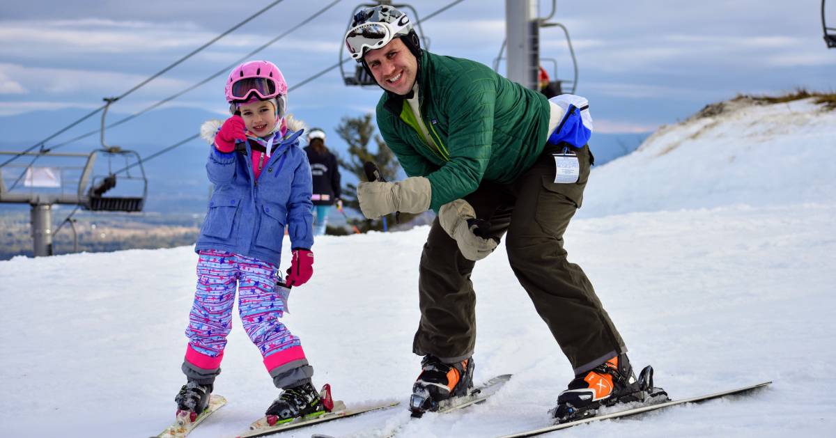 dad and daughter posing to ski