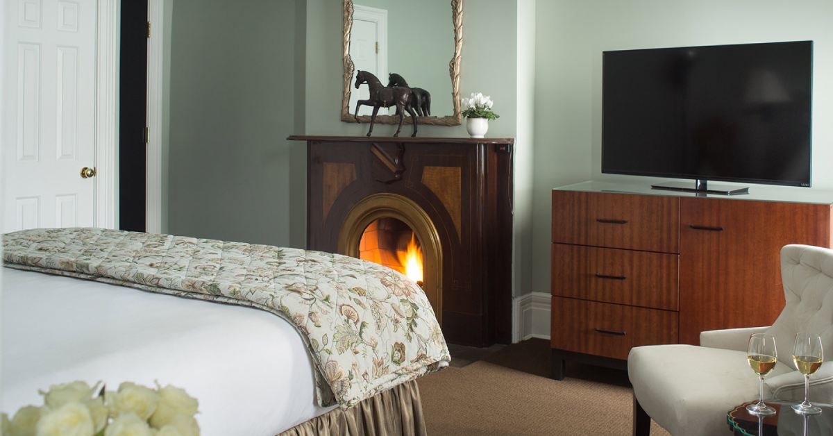 a fireplace in a hotel room near a tv and bed
