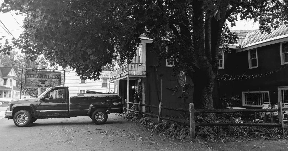 black and white image of restaurant with truck in front