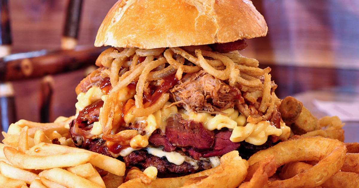 large burger with onion rings, mac and cheese, fries, and more