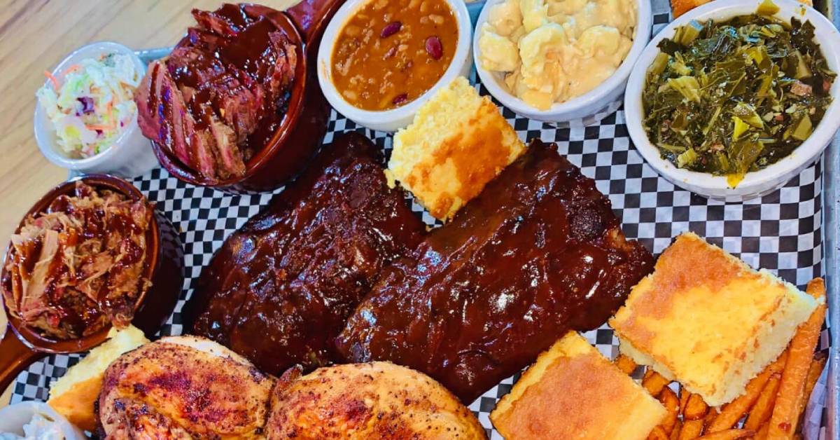 overhead photo of bbq ribs, cornbread, chicken, brisket, and other sides