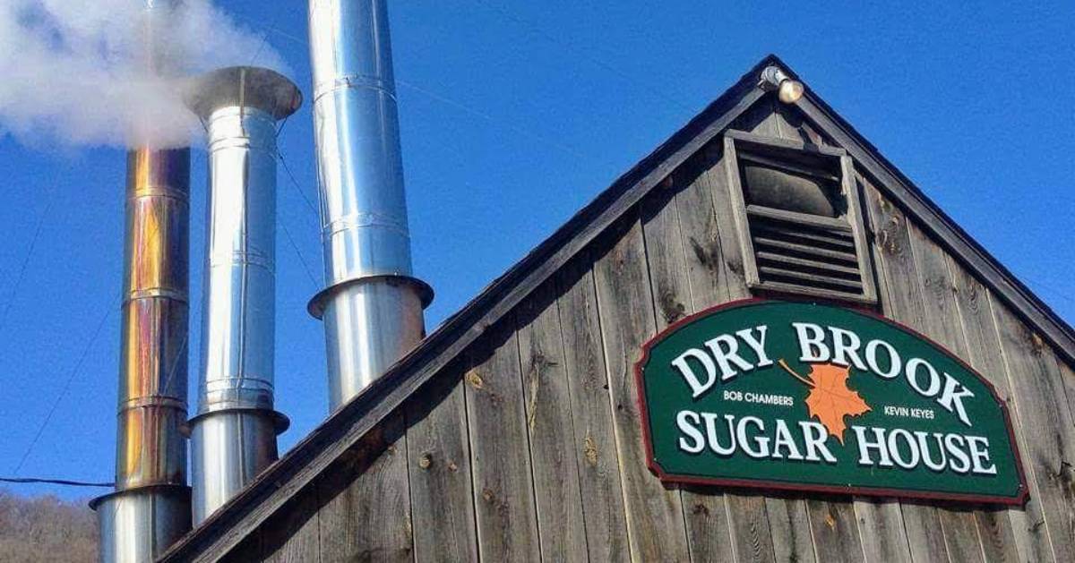 the top of Dry Brook Sugar House with sign and smoke stacks