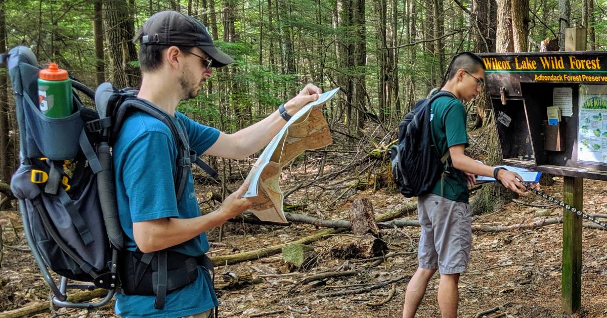 hiker reading a map at trailh ead