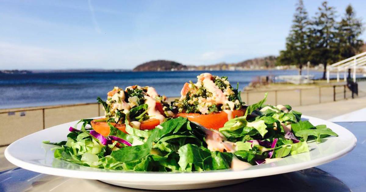 plate of food on patio table near the beach