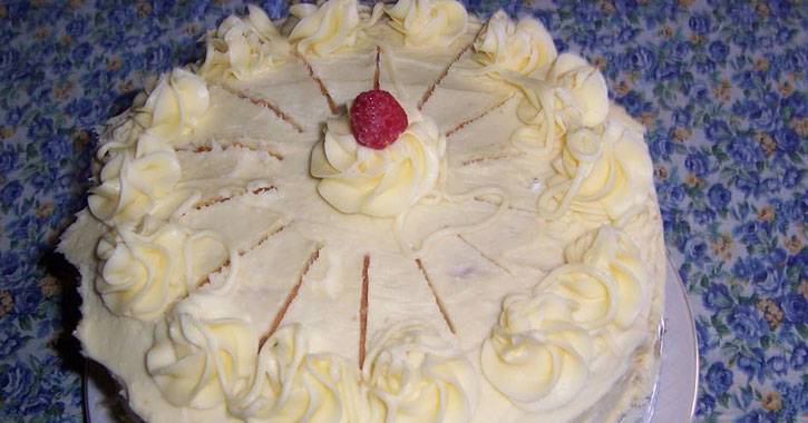 a cake with white frosting and raspberry
