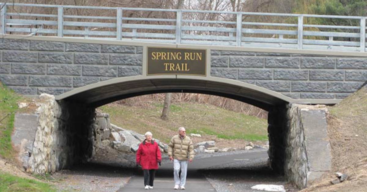 two people walking under bridge