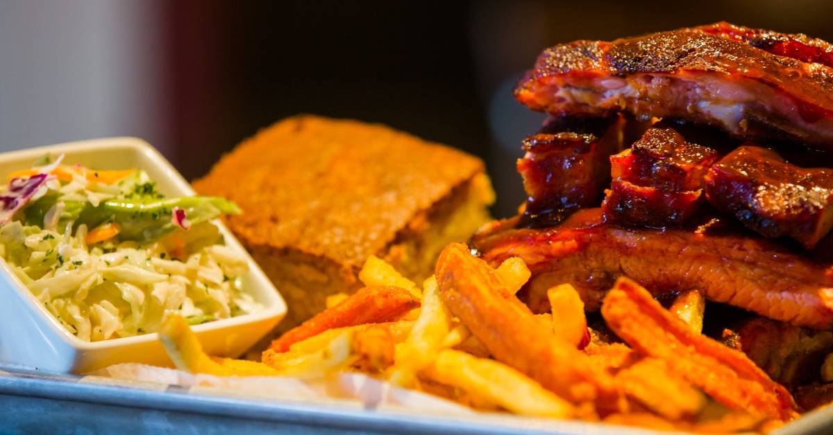 plate of ribs, corn bread, coleslaw, and fries