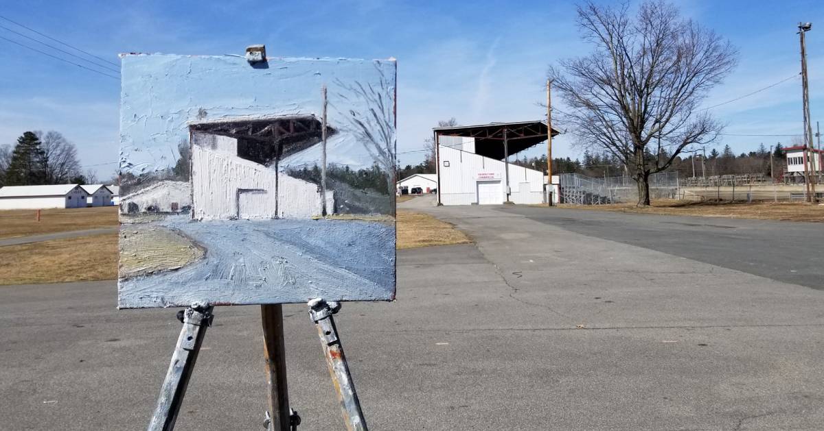 painting of a warehouse set up in front of the actual warehouse