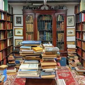 piled books in a bookstore and bookshelves