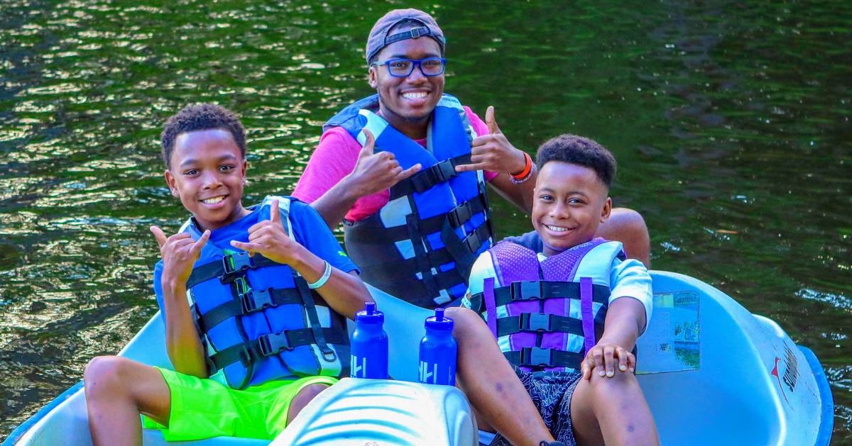 counselor and two campers on boat