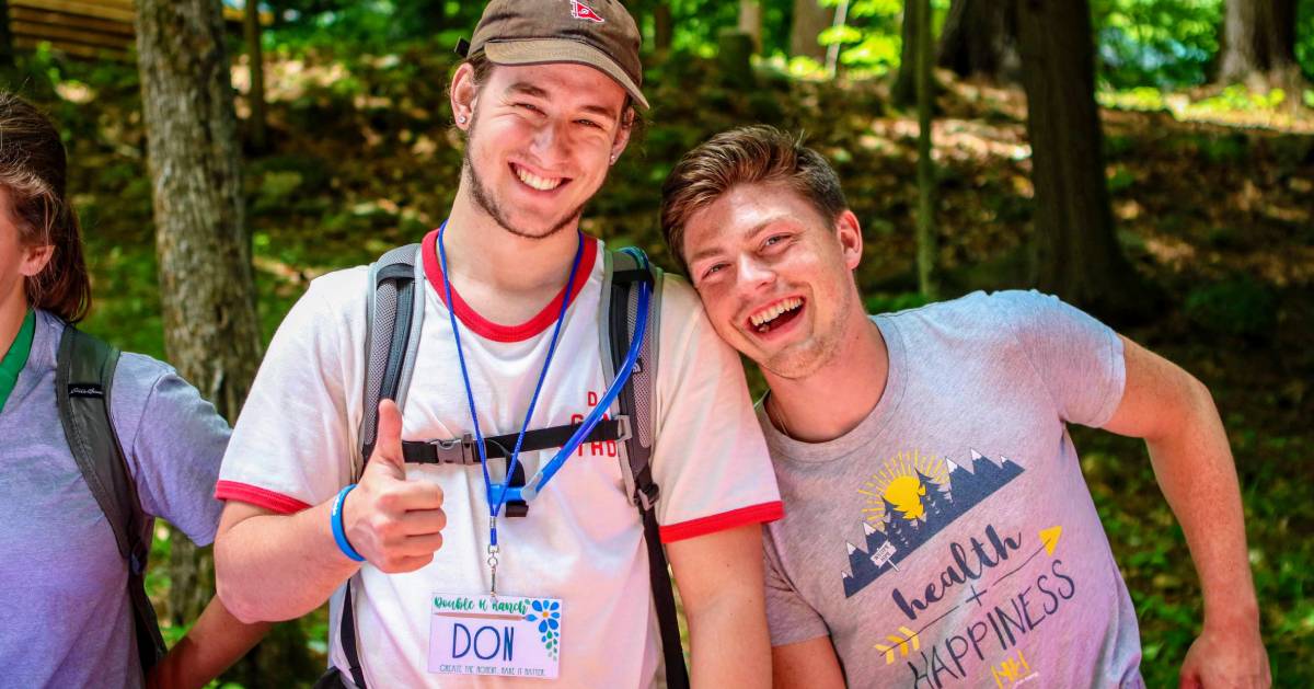 Two Counselors giving thumbs up in woods