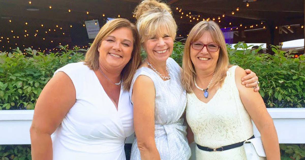 three women wearing white at a gala