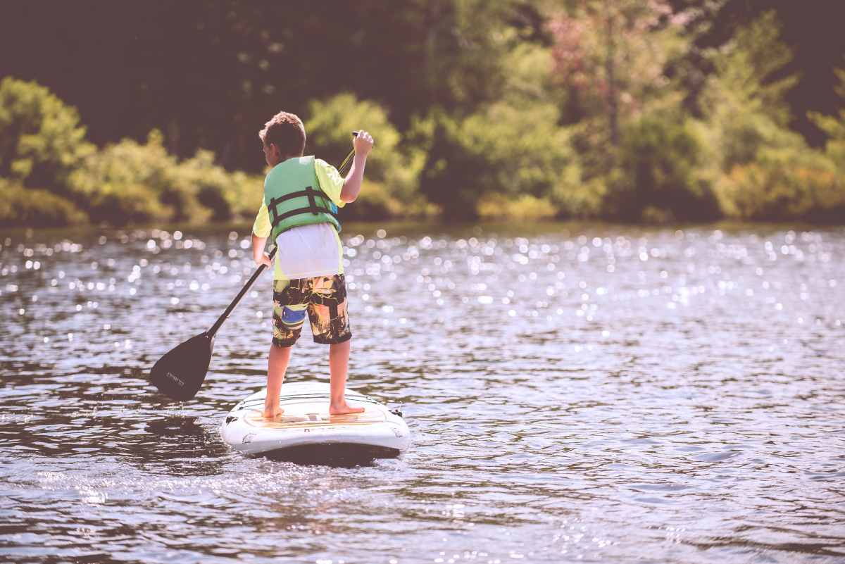 boy paddling on stand up paddleboard