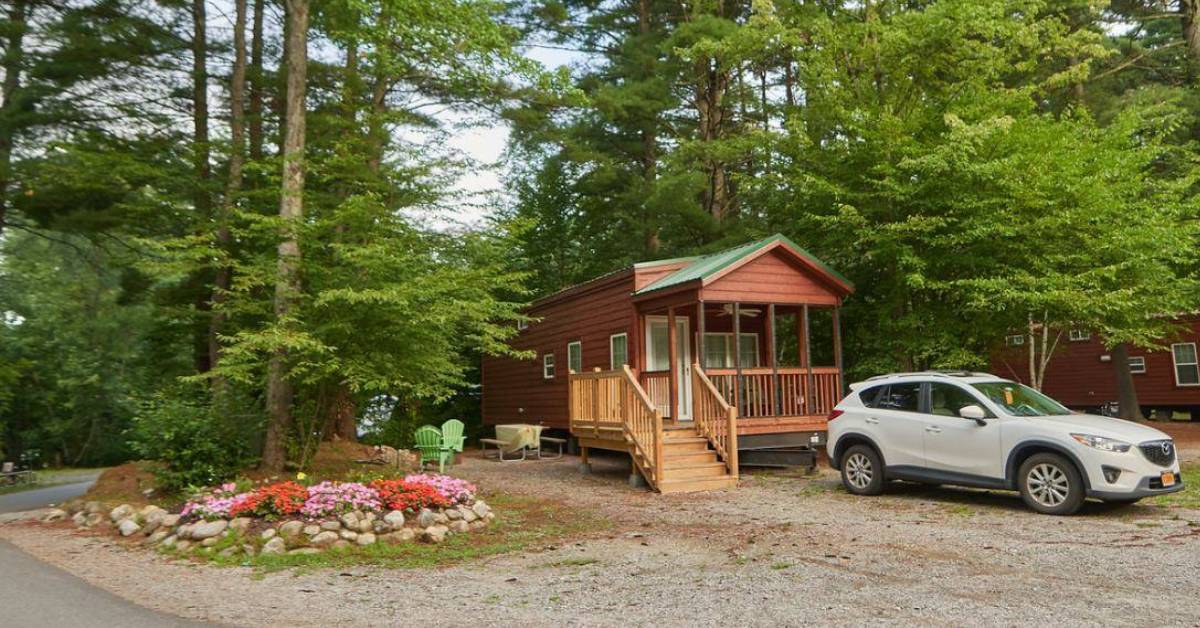 a car near a wooden cottage