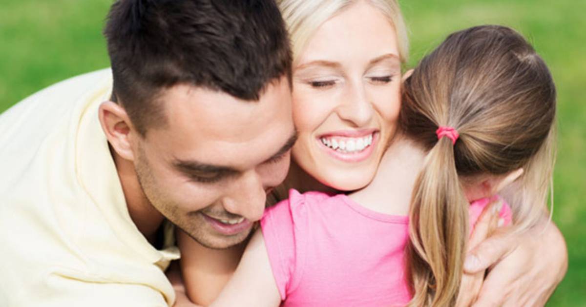 dad, mom, and daughter hugging