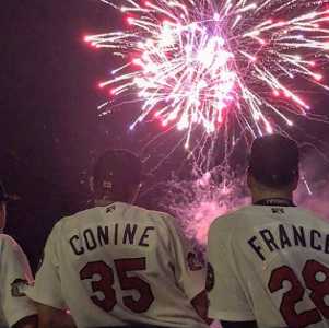 three baseball players watching fireworks