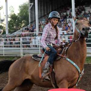 girl riding on a horse in an arena