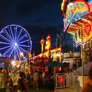 people walking around a summer fair at night