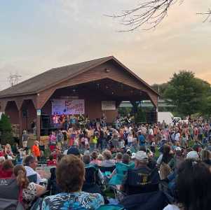crowd of people watching a concert at an outdoor amphitheater