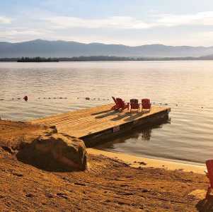 beachfront with adirondack chairs at sunset