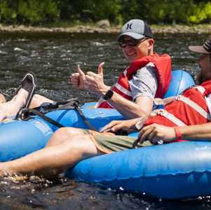a group of people lazy river tubing in blue tubes
