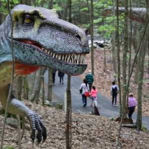 people on walk by dinosaur