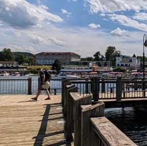 people walking on dock on lake george