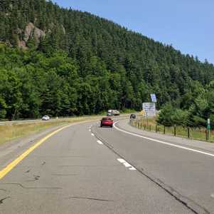 road with cars in the adirondacks near lake placid