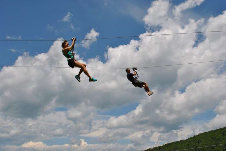 two people zip-lining next to eachother