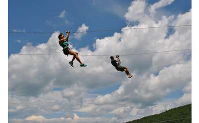 two people zip-lining next to eachother