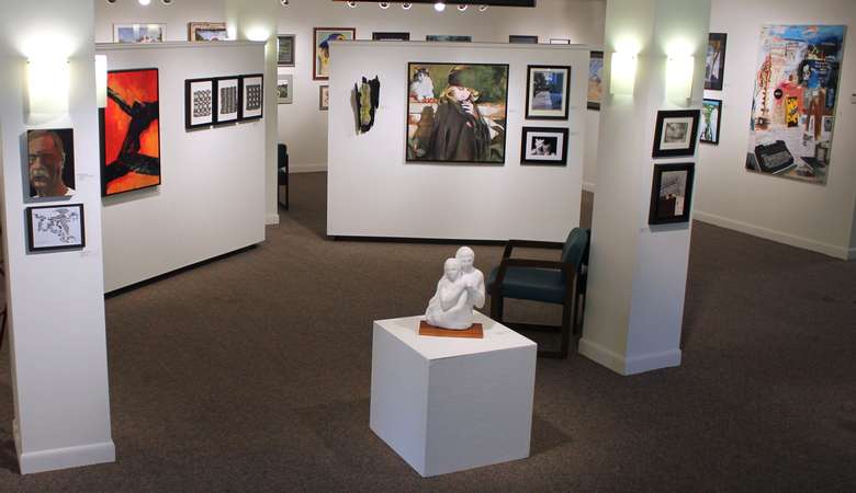 art gallery with sculptures and pictures hanging on the walls