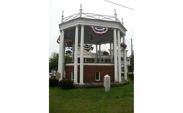 bandstand with red, white, and blue banners and green grass in front