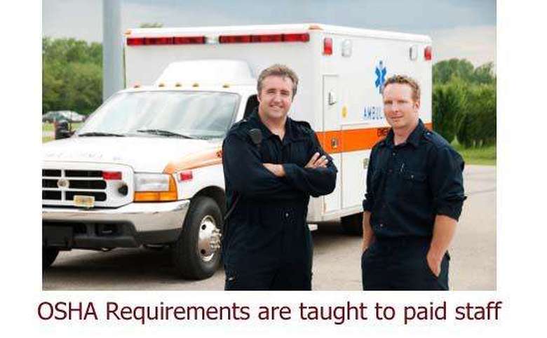 two emergency responders standing in front of an ambulance