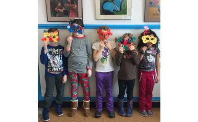 five kids holding homemade masks over their faces