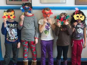 five kids holding homemade masks over their faces