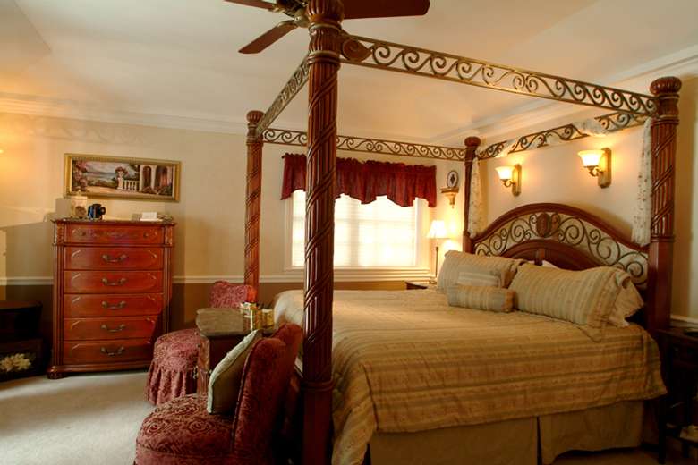 a large four poster wooden bed in a bedroom