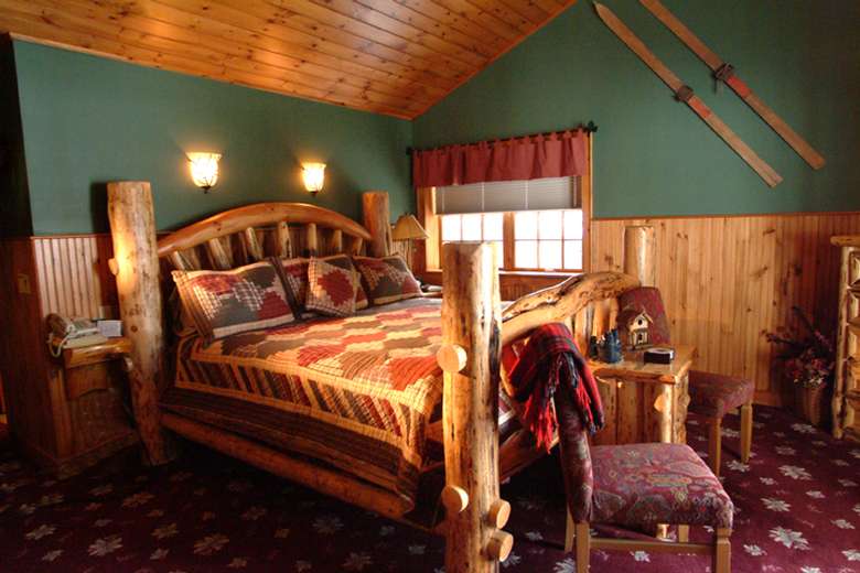a wooden bed in a cabin-like bedroom