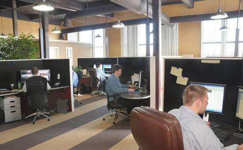 an office room with people at various cubicles